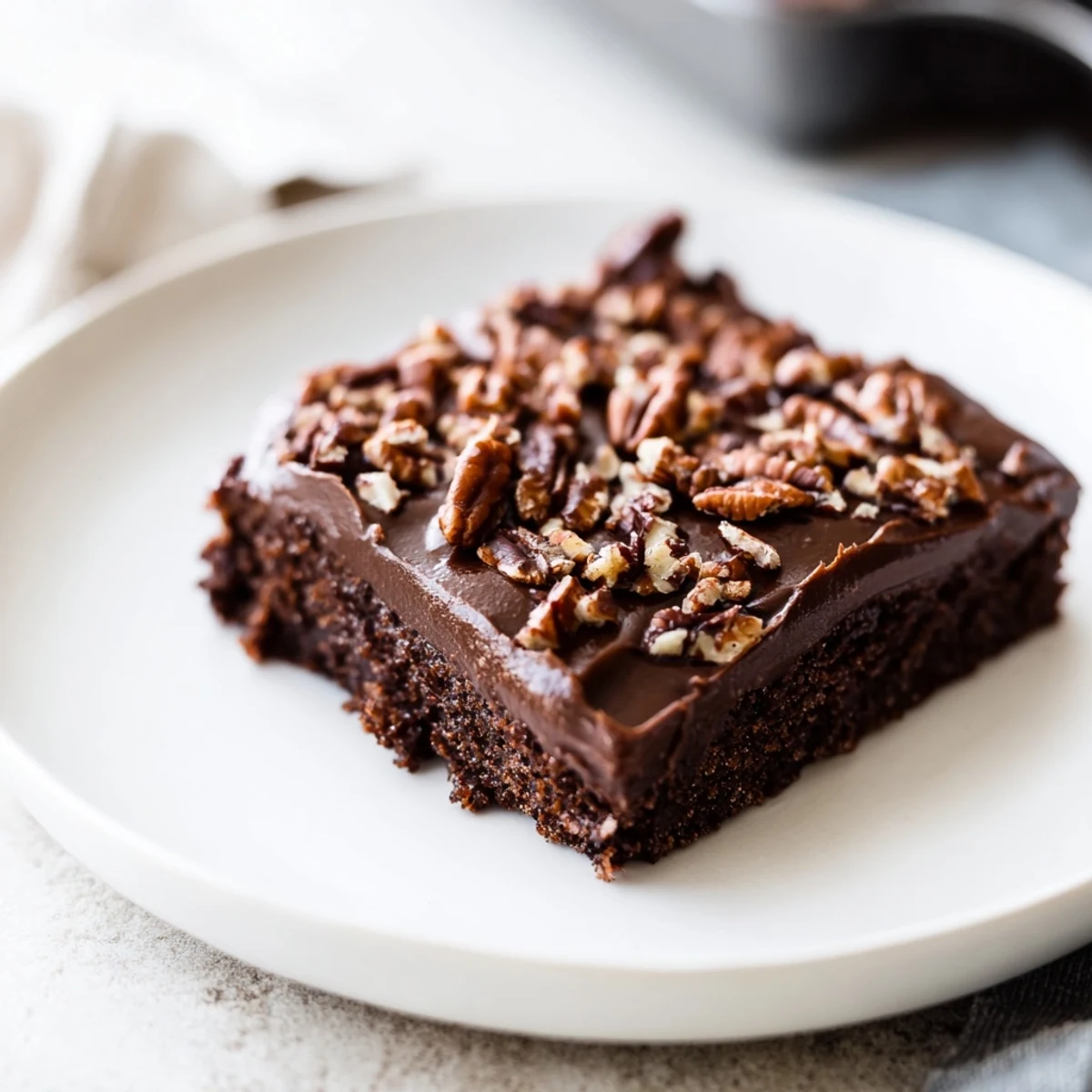 Warm fudgy chocolate Texas Sheet Cake glistening on a baking sheet, ready to serve and indulge.