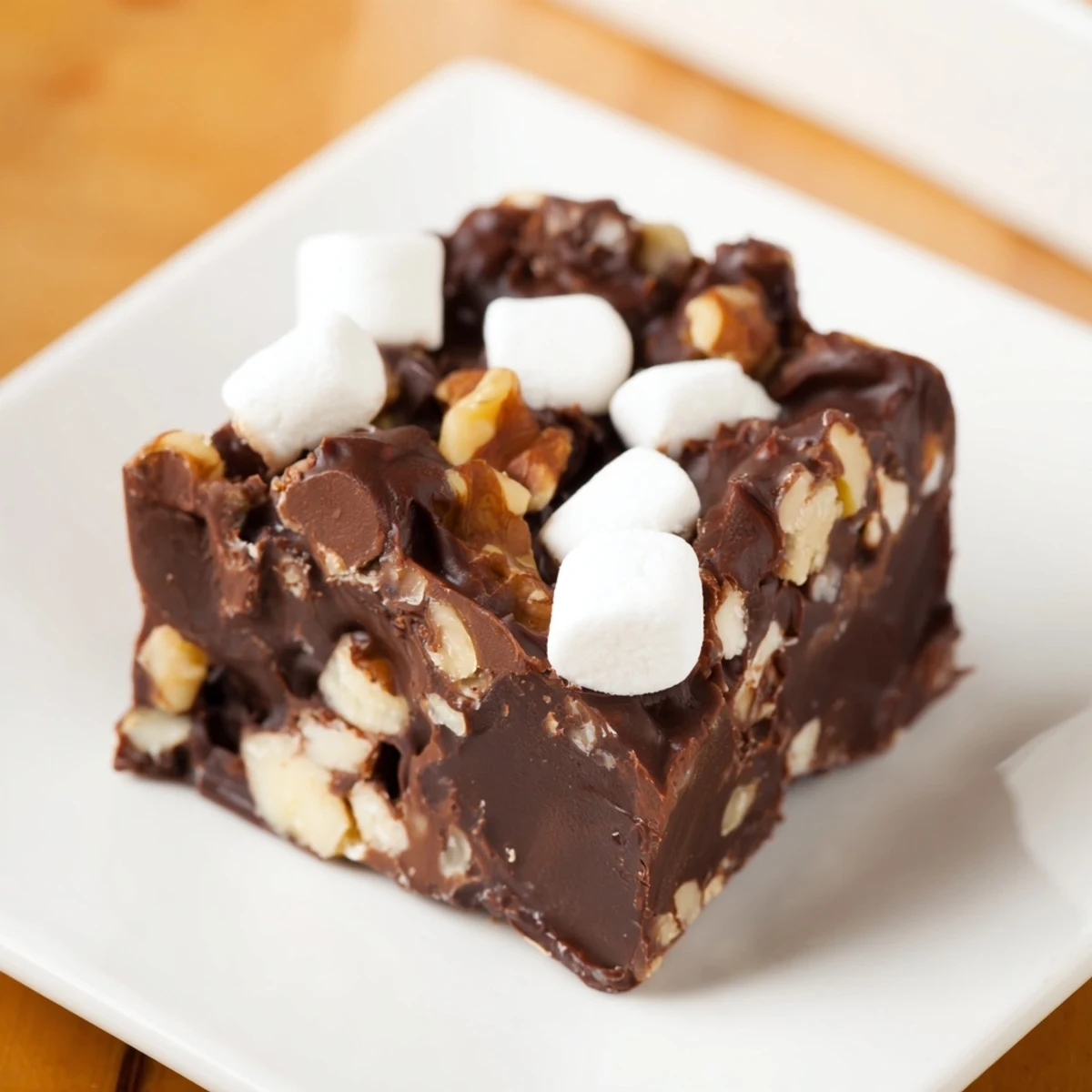 A square of rich, decadent Rocky Road Fudge, studded with marshmallows and nuts, ready to enjoy.