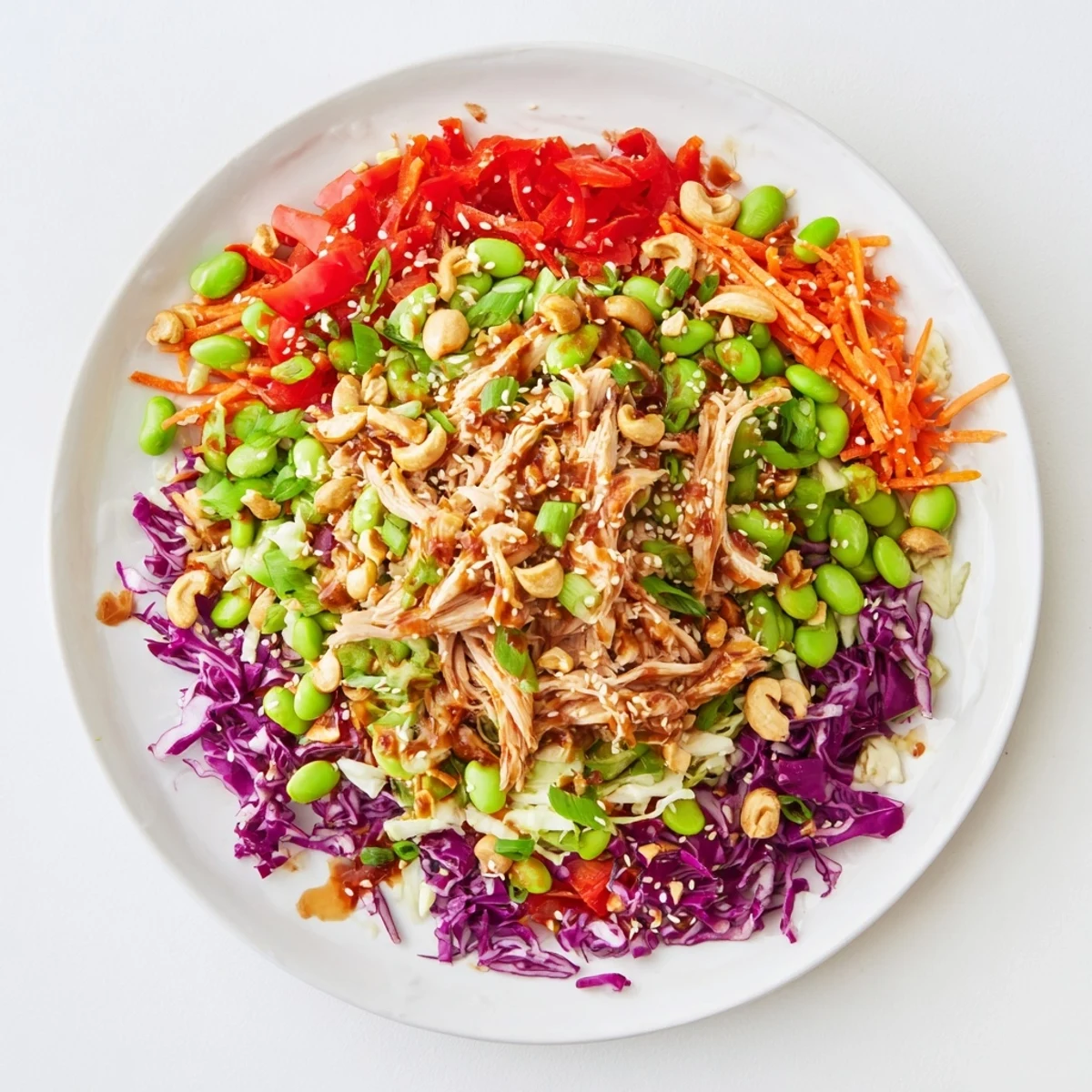 Vibrant Edamame Crunch Chicken Salad with shredded chicken, crisp cabbages, carrots, and toasted sesame seeds in a zesty ginger dressing.