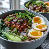 Sliced chicken and sesame seeds top Healthy Miso Chicken Noodle Bowls garnished with fresh cilantro.