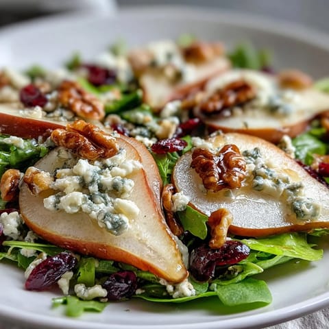 Savory Pear Gorgonzola Salad with toasted walnuts and sweet honey-balsamic drizzle.