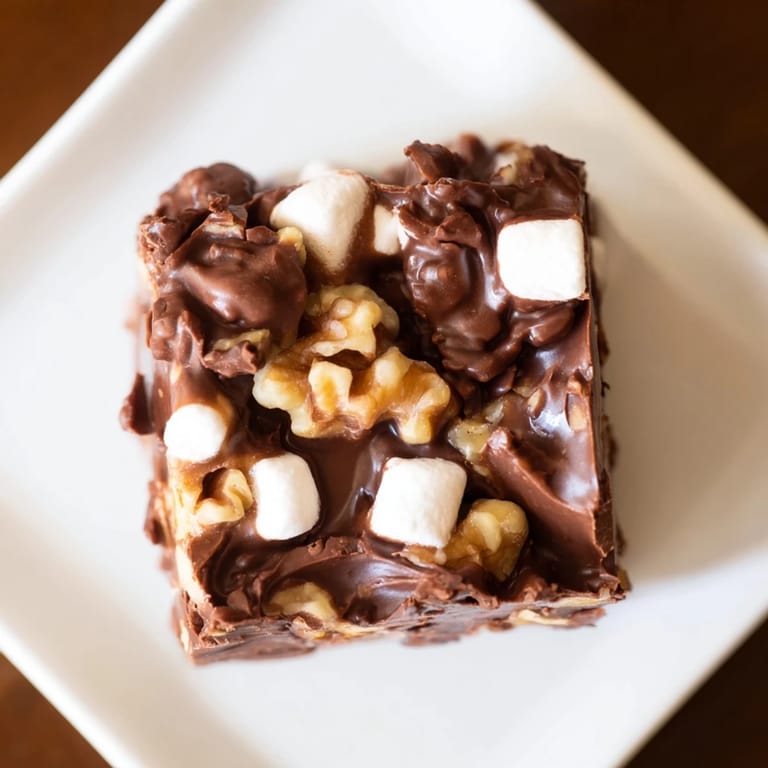 Close-up of freshly cut Rocky Road Fudge, a creamy texture with marshmallow pieces and nut crunch.
