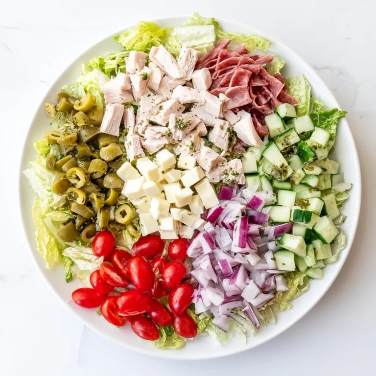 Close-up of Italian Deli Chopped Chicken Salad featuring chopped salami, provolone, and pepperoncini for a zesty bite.